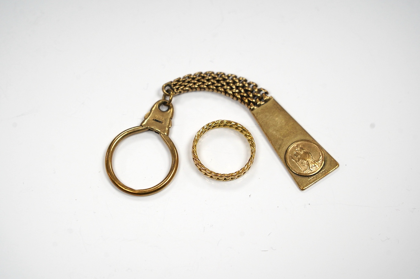 A 9ct gold key chain, with engraved inscription and a yellow metal band, gross weight 17.2 grams. Condition - fair